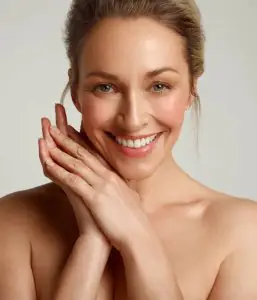 Mujer sonriente con piel saludable tras tratamiento dermatológico estético