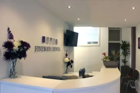 Área de recepción en Fiveways Dental Practice con decoración moderna y asientos