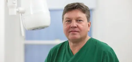 طبيب أسنان يرتدي زي أخضر مع جهاز أشعة في Edinburgh Dental Specialists