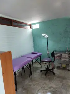 غرفة علاج في عيادة لوميدنت بسرير فحص وكرسي وأدراج طبية