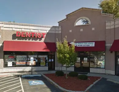 الواجهة الخارجية لمركز International Dental Center مع مظلة حمراء وموقف لذوي الاحتياجات الخاصة
