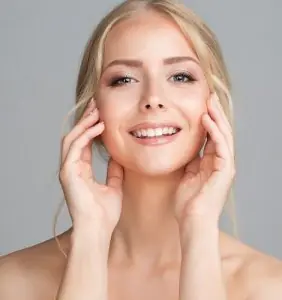 امرأة مبتسمة ببشرة صافية، مثال لنتائج التجميل في Jaibaji Plastic Surgery