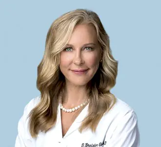 طبيبة في عيادة Medical Expert Plastic Surgery Face and Neck ترتدي معطفًا أبيض