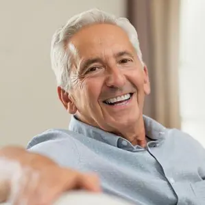 Paciente mayor con sonrisa saludable tras tratamiento dental en Dental Pearls