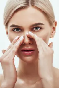 امرأة تلمس أنفها، مفهوم تجميل الأنف في عيادة Tamplen Plastic Surgery