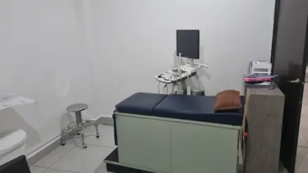 غرفة فحص نسائية مع جهاز موجات فوق صوتية في عيادة Ginecologo Playa del Carmen