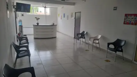 غرفة انتظار في عيادة Ginecologo Playa del Carmen بمقاعد حديثة ومكتب استقبال