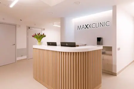 مكتب استقبال في MaxxClinic بتصميم حديث وترتيب زهور