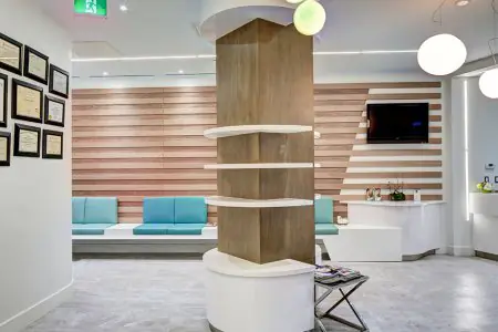 منطقة انتظار عصرية في Toronto Plastic Surgery Clinic مع لمسات خشبية ومقاعد