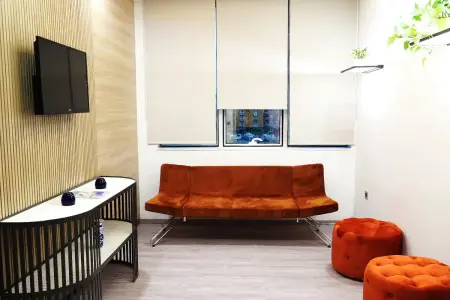 Sala de espera en ERDEM HOSPITAL con asientos naranjas modernos y TV