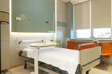 Habitación de paciente en ERDEM HOSPITAL con cama moderna y ventana grande