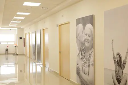 Pasillo de Hospital Alhma con habitaciones y grandes murales de salud