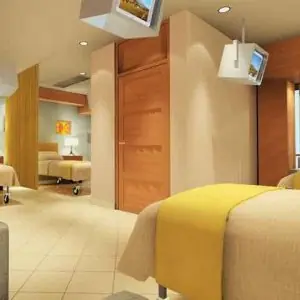 Sala de recuperación de pacientes en Moolchand Medcity South Delhi con camas modernas y televisores