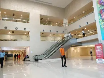 ردهة واسعة في مستشفى Manipal مع سلالم كهربائية وتصميم حديث