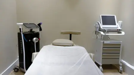 غرفة علاج تجميلي مزودة بأجهزة ليزر حديثة في عيادة Trustmed