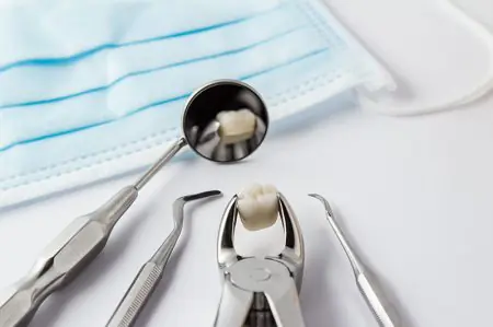 Instrumentos dentales y mascarilla en Dental Fraternity, herramientas de extracción dental