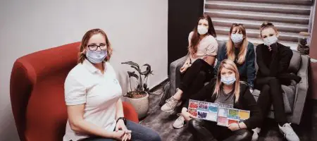 طاقم مركز Estetica لطب الأسنان في منطقة الانتظار يرتدون كمامات طبية
