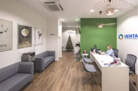Recepción en la clínica DentaCare Garbary con asientos modernos y pared verde