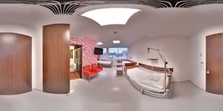 Habitación de pacientes en Perfect Clinic con camas modernas y área de descanso