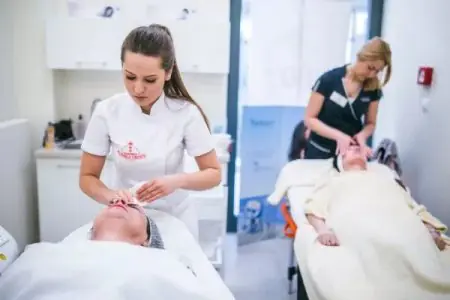 غرفة علاج الوجه في عيادة Gdansk Beauty Clinic مع طاقم يجري إجراءات العناية بالبشرة