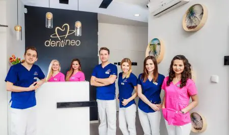 استقبال عيادة Dentineo مع طاقم الأسنان بالزي الرسمي وديكور حديث