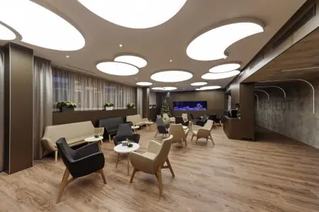 Sala de espera moderna en Perfect Clinic con asientos elegantes y gran acuario