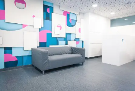 Área de recepción en Dental Care Center Black Swan con decoración moderna y sofá para pacientes