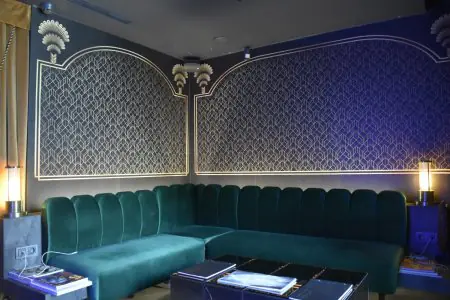 Sala de espera para pacientes en Catwalk Nisantasi Clinic, decoración moderna con sofá verde