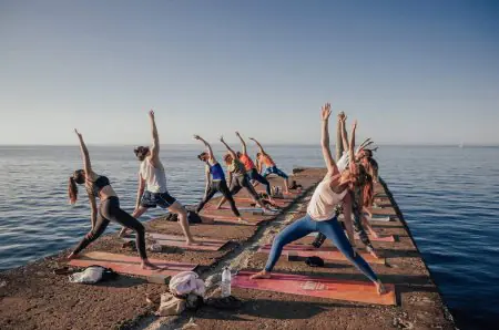جلسة يوغا خارجية بجانب البحر في عيادة Salty Pelican Retreats الصحية