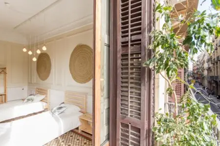 Habitación de pacientes con dos camas y balcón en Yoga Weeks Barcelona