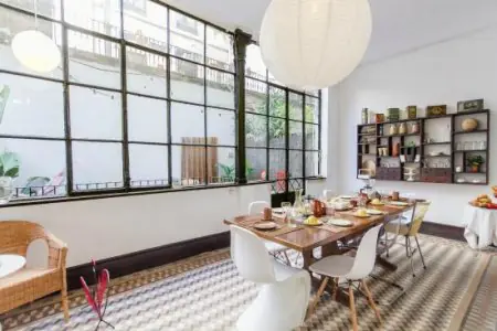 Comedor de la clínica Yoga Weeks con grandes ventanales y decoración moderna en Barcelona