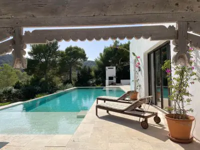 منطقة مسبح خارجي في Malva Retreats Ibiza مع كراسي استلقاء وإطلالة على الحديقة