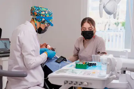 غرفة علاج الأسنان في White Dental Turkey مع أطباء يجرون إجراءً