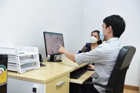 غرفة استشارة في Wellmed Bangkok Clinic مع طبيب ومريض يرتديان الكمامات