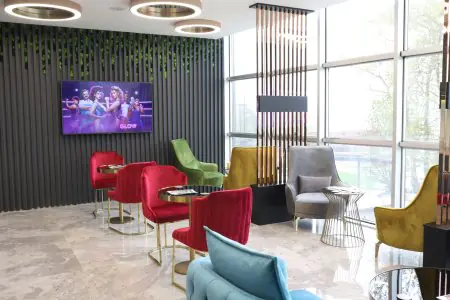 منطقة انتظار حديثة في Özel Yalova Dental Park بكراسي ملونة ونوافذ كبيرة