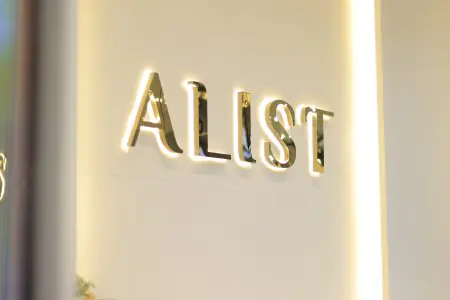 Logotipo iluminado de CHIANG MAI ALIST CLINIC en pared interior moderna