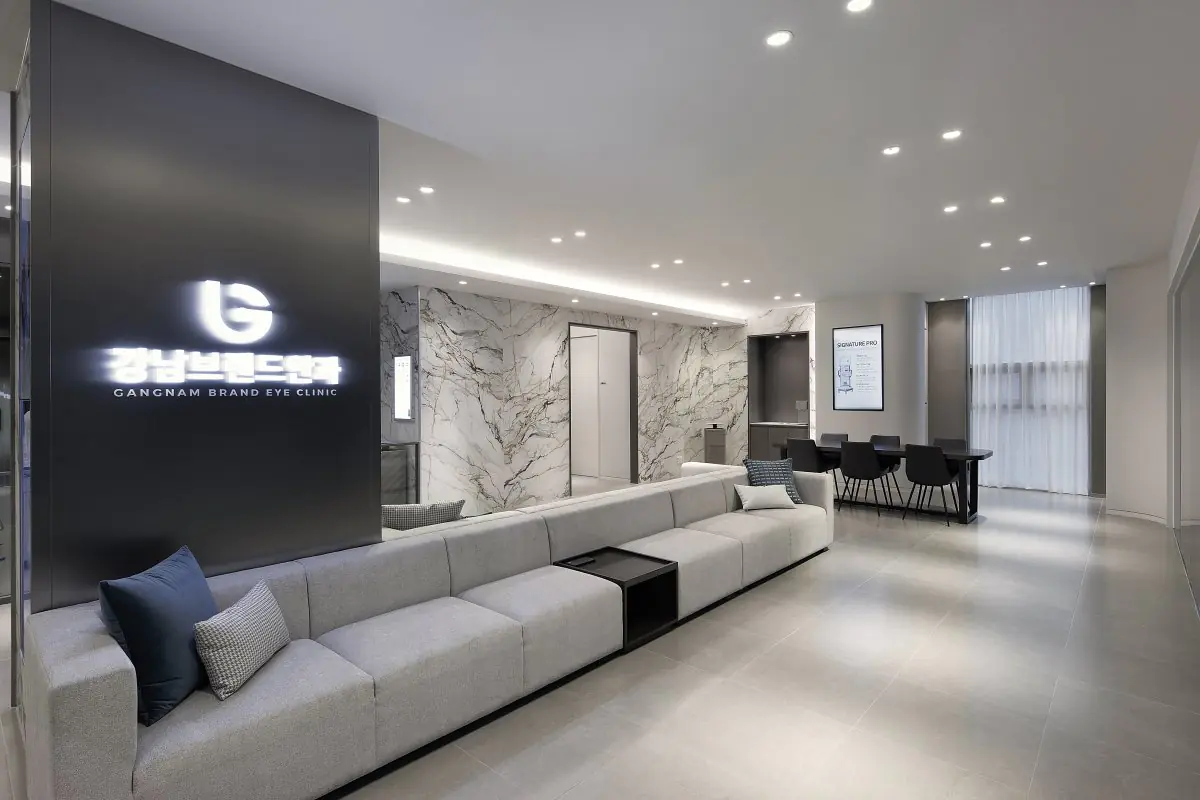 منطقة انتظار حديثة في GANGNAM BRAND Eye Clinic بجدران رخامية ومقاعد مريحة