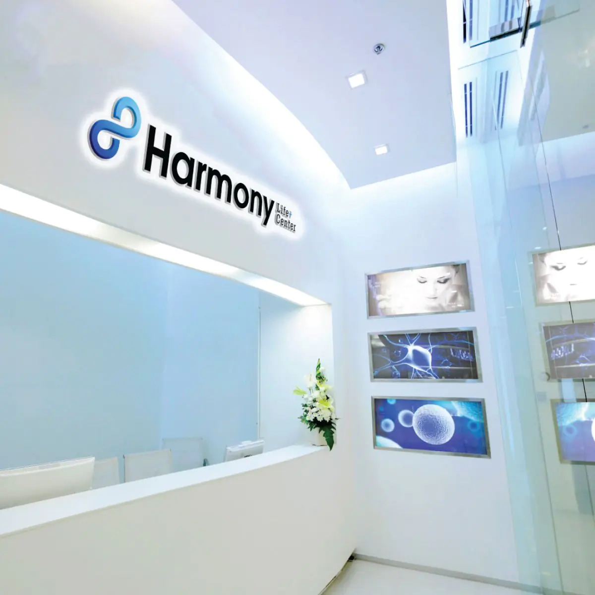 Зона ресепшн в Harmony Life Center с современным интерьером и медицинскими картинами