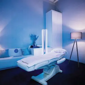 Sala de tratamiento moderna en Harmony Life Center con camilla médica e iluminación ambiental