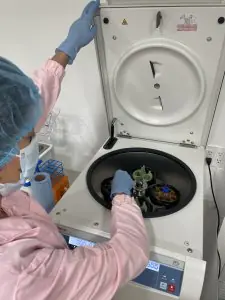 Técnico de laboratorio usando centrífuga en Giostar Stem Cell Therapy Playa del Carmen