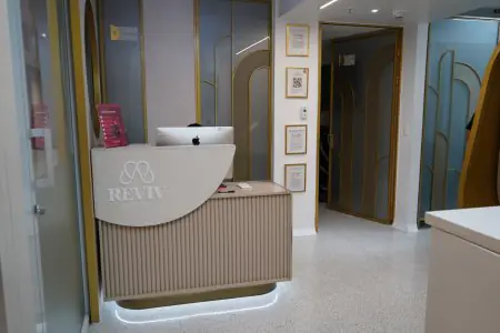 Mostrador de recepción en Reviv Clinic con decoración moderna y detalles dorados