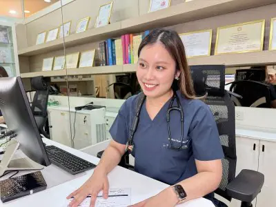 طبيبة في PrimeCare Bkk على مكتب الاستشارة مع شهادات وكتب طبية