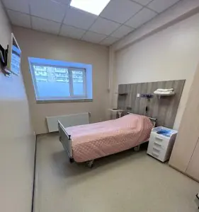 Habitación de paciente en Dmytrii Homola Clinic con cama hospitalaria y comodidades modernas
