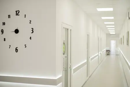 ممر مضاء مع ساعة حائط في Expert Clinic، منشأة طبية حديثة