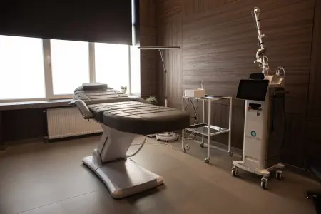 غرفة علاج تجميلي مع جهاز ليزر في عيادة الدكتور يفغين لوغفينوف