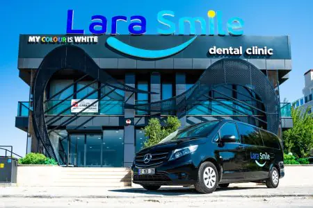 الواجهة الحديثة لعيادة Lara Smile لطب الأسنان مع سيارة نقل مرضى تحمل الشعار