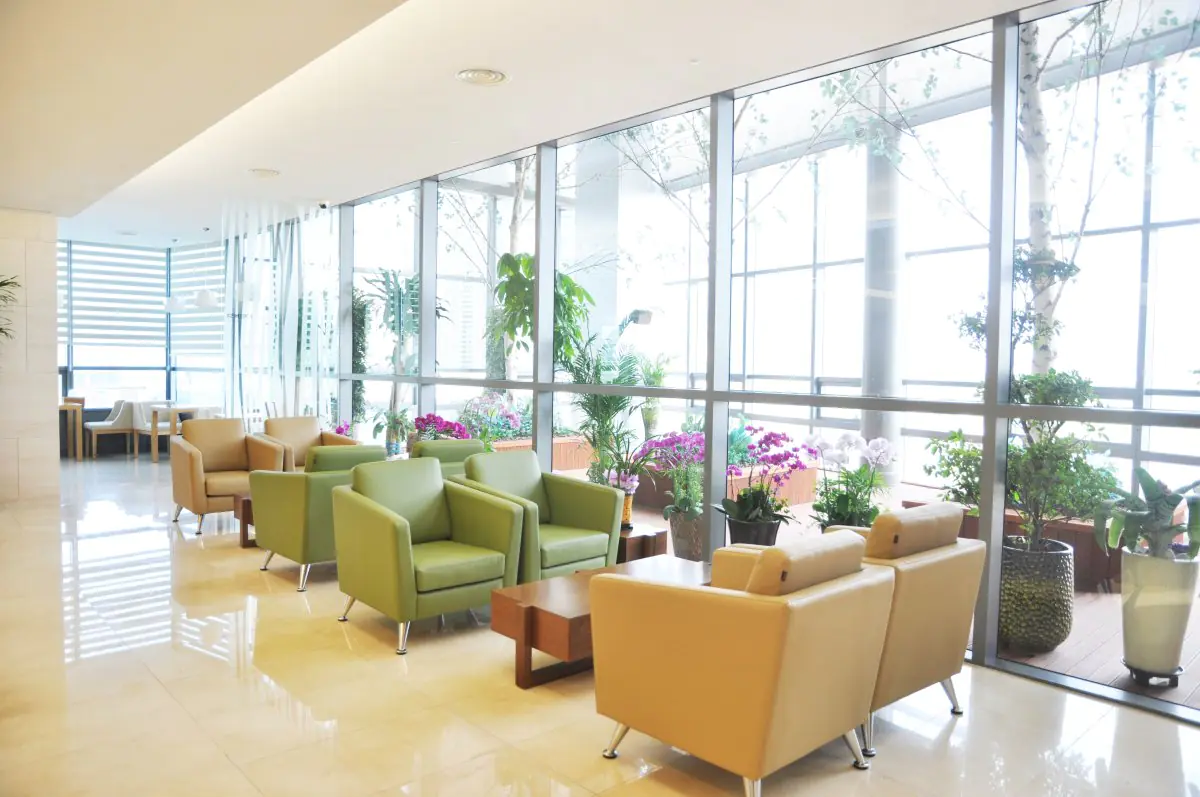Waiting area at Jian Health Promotion Center, bright interior with plants and lounge chairs