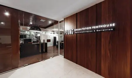 Área de recepción en PYONG Rehabilitation Group con interior moderno de madera