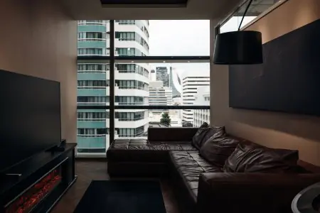 Sala de espera para pacientes en PYONG Rehabilitation Group con vista a la ciudad y mobiliario moderno