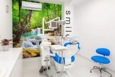 غرفة علاج الأسنان في Excelentis Dental Center بمعدات حديثة وجدارية طبيعية